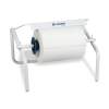 Free-standing paper towel roll dispenser with a large white roll ready to dispense, on a metal frame with a serrated edge.